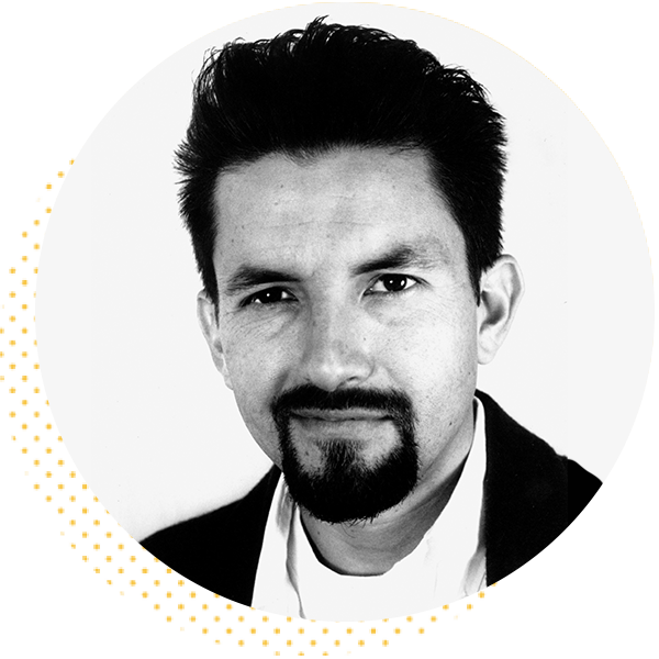 Portrait of a man with dark hair and a goatee, wearing a black jacket over a white shirt, set against a circular background. The image conveys a professional and approachable demeanor, suitable for a business or personal profile.
