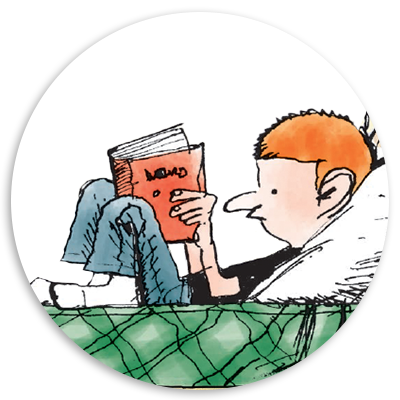 A young boy with orange hair sits comfortably on a bed, reading a book titled 