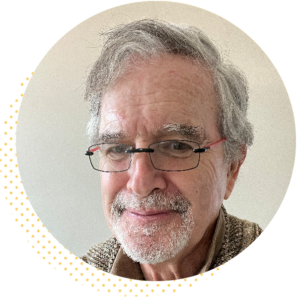 Portrait of a smiling older man with gray hair and glasses, wearing a sweater, against a light background. Ideal for articles on aging, wisdom, or personal stories.