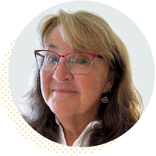 Smiling woman with long, wavy hair and glasses, wearing a white blouse. The image features a circular crop with a light background and dotted border, conveying a friendly and approachable demeanor.