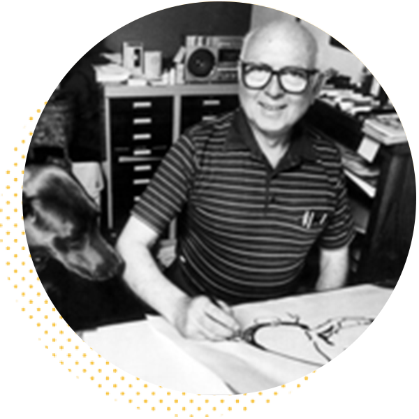 Elderly man with glasses drawing on paper in an office setting, accompanied by a dog, surrounded by artistic materials and shelves.