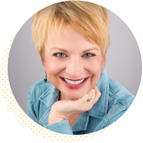 Smiling woman with short blonde hair wearing a blue jacket, resting her chin on her hand, against a light gray background. Ideal for showcasing personal branding or professional services.
